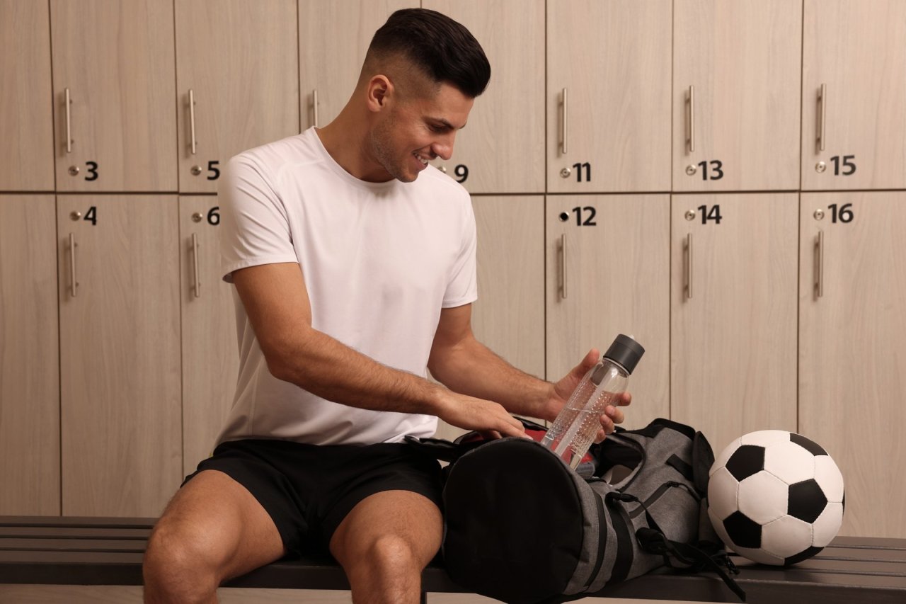 Football player packing a bag in the changing room
