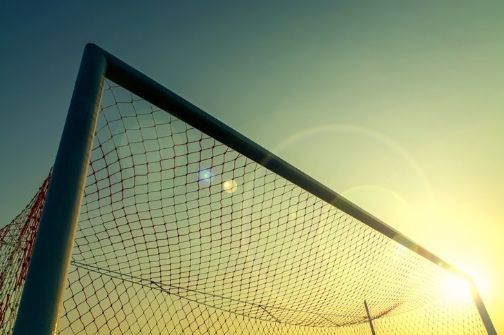 A football goal with the sun behind it