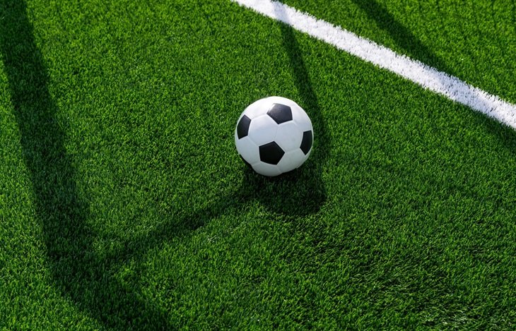 A black and white football on a pitch