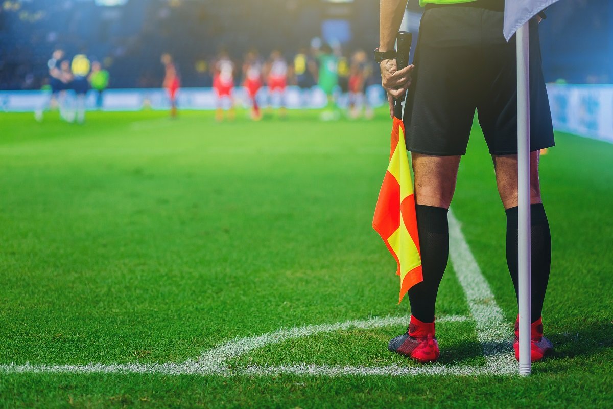 Assistant referee and football corner flag