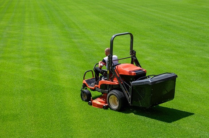 Ground staff cutting the grass on a football pitch