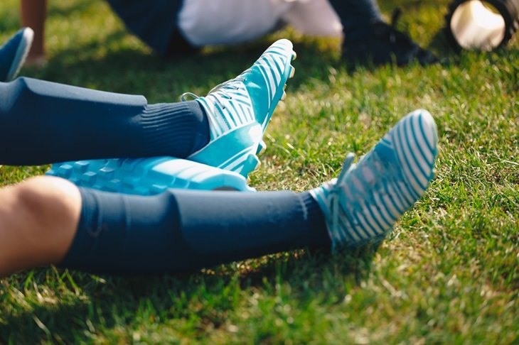 A youth player with shinpads, socks and football boots on