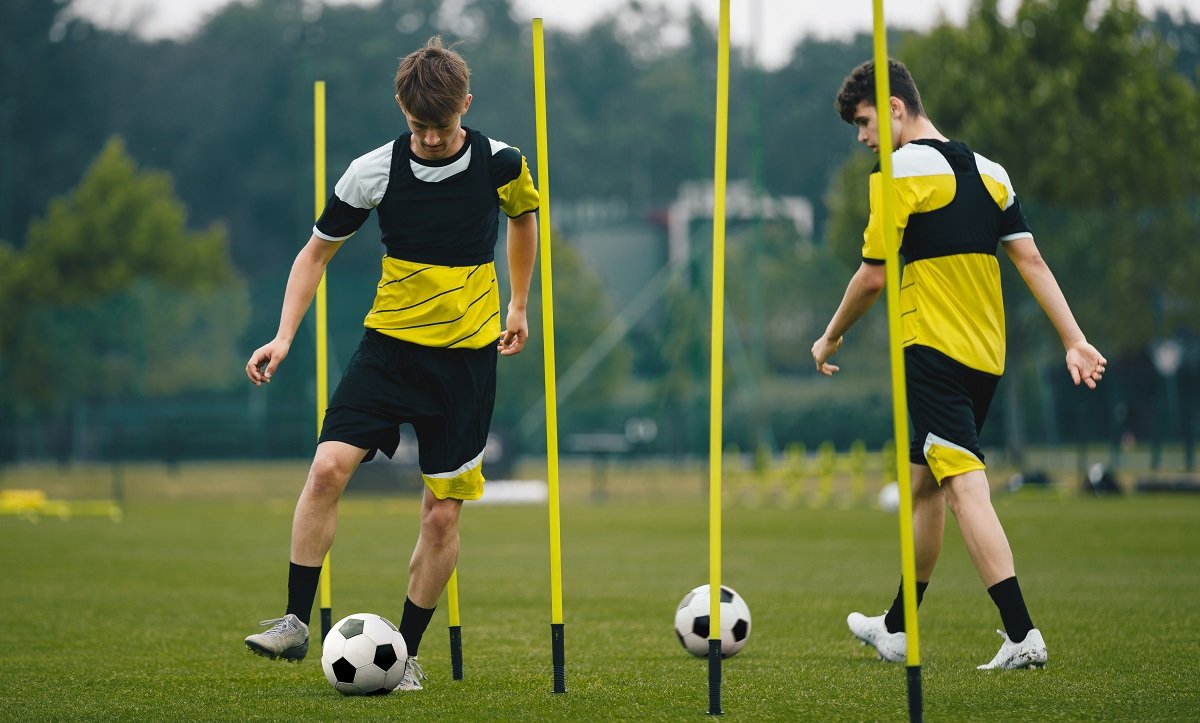 Football players training with poles