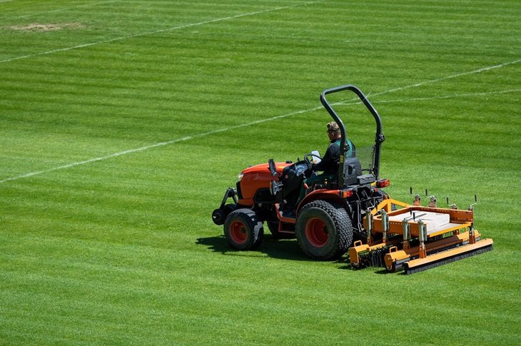 Ground staff prepare a pitch ahead of a game