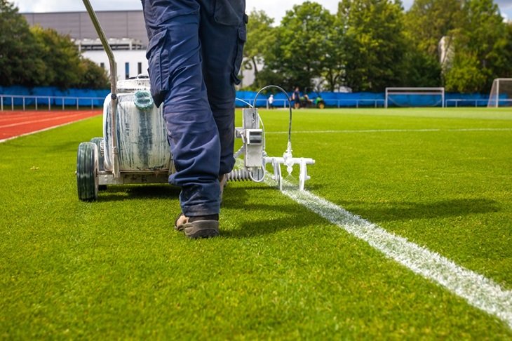 A groundsman marks out a football pitch