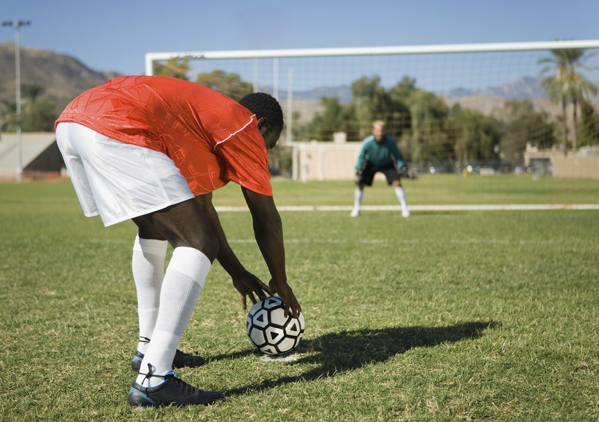 A football player prepares to take a penalty kick
