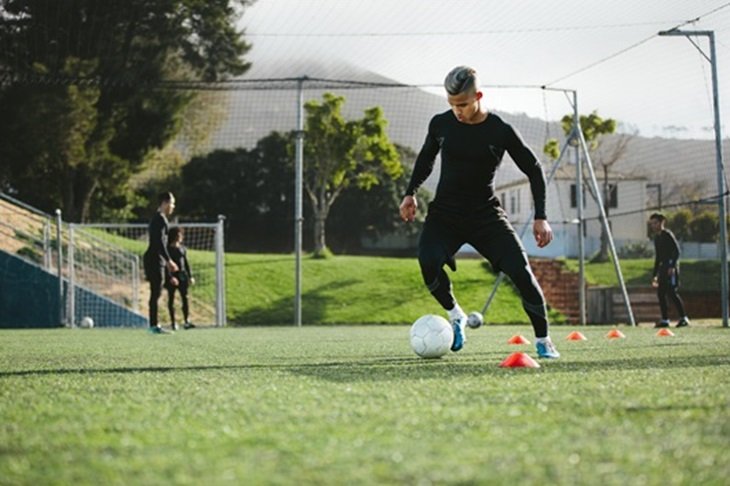 A player dribbles with a football